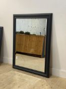 A contemporary wall hanging mirror, the bevelled plate within a charcoal grey painted beech frame