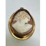 A 18ct gold set oval cameo brooch/pendant, the shell carved cameo depicting a portrait of a young