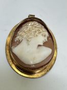 A 18ct gold set oval cameo brooch/pendant, the shell carved cameo depicting a portrait of a young