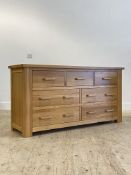 A contemporary oak chest, fitted with three short and four longer drawers, raised on stile