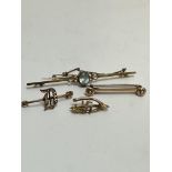 A collection of four brooches including a 9ct gold Aquamarine set bar brooch with safety chain, (L x