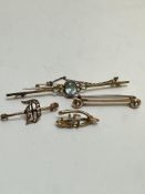 A collection of four brooches including a 9ct gold Aquamarine set bar brooch with safety chain, (L x