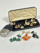 A box containing a collection of gilt metal and mother of pearl studs, a pair of green stone cushion