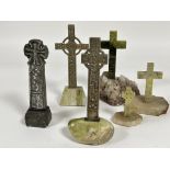 A group of two cast metal Scottish Celtic crosses decorated with figures, knots etc mounted on green
