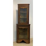 An Edwardian walnut two part corner cabinet in the Chippendale taste, with blind fret to freize