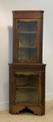 An Edwardian walnut two part corner cabinet in the Chippendale taste, with blind fret to freize
