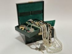 A green leather jewellery box containing a yellow metal bar brooch set green stone and a