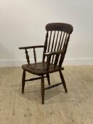 A Victorian stained mahogany Windsor type commode chair, with comb back over saddle seat, raised