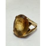 A 18ct gold citrine dress ring, the oval stone set in high claw setting, (L x 1.9cm x W 1.4cm),