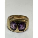 A 18ct gold two stone Amethyst ring in rub over setting, (L x 1cm x W 0.5cm), table of each stone