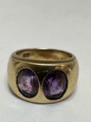 A 18ct gold two stone Amethyst ring in rub over setting, (L x 1cm x W 0.5cm), table of each stone
