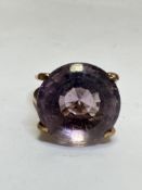 A 9ct gold circular Amethyst faceted cut dress ring mounted in four claw setting on double shank.(