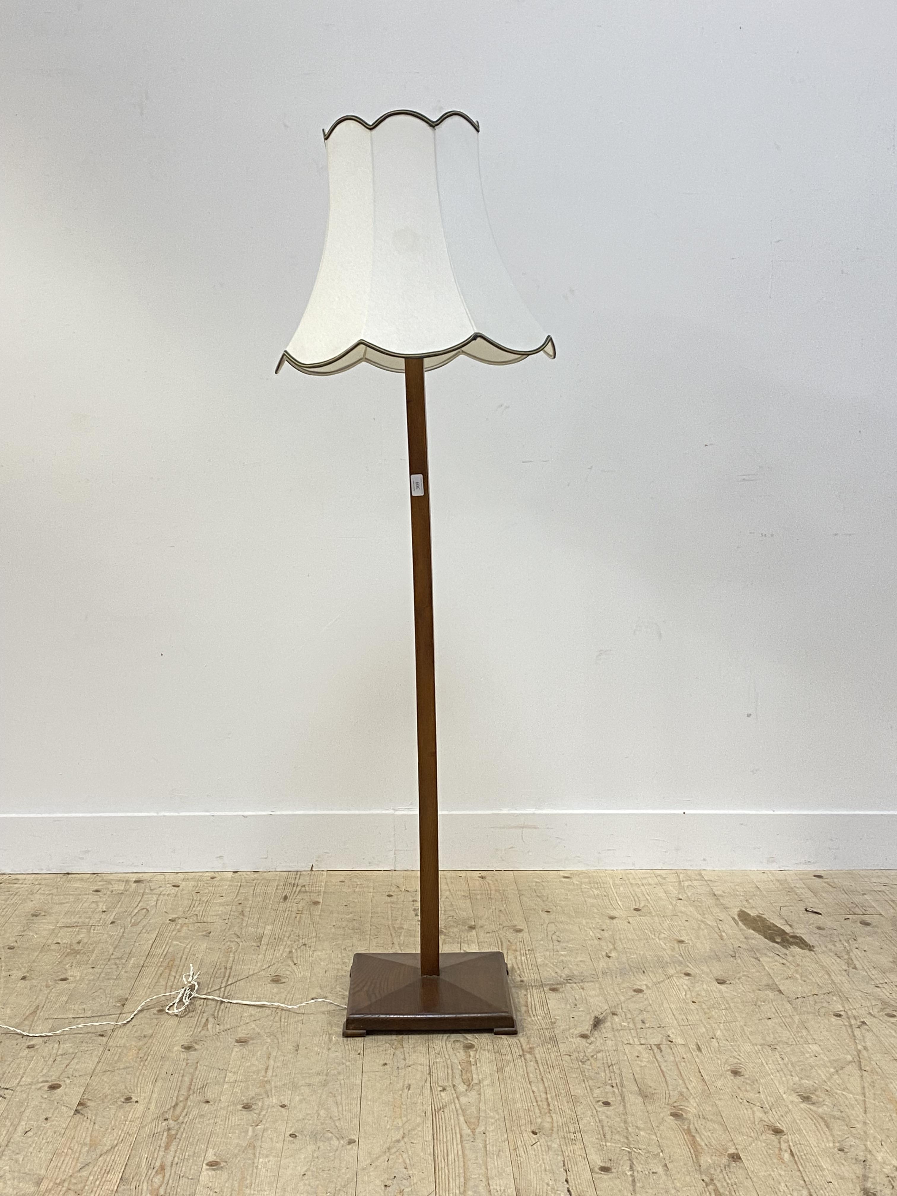 A mid 20th century stained ash lamp standard, the square tapered column raised on a square base,