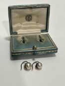 A pair of Edwardian yellow metal mounted natural pearl stud earrings of silver colour, one