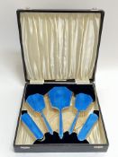 A boxed guilloche enamel on silver deposit dressing table set comprising two clothes brushes, two