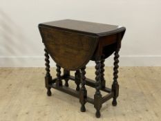 An early 20th century oak gateleg table, the oval duo drop leaf top raised on spiral turned supports