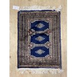 A small hand knotted bokhara type rug or mat, three guls within a deep border 43cm x 68cm