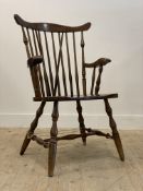 A 20th century stained beech Windsor type chair, with comb back, open arms, saddle seat, raised on