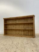 A 20th century varnished pine open bookcase fitted with two fixed shelves, H92cm, W164cm, D24cm