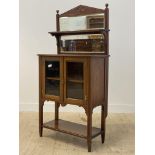 An Edwardian walnut side cabinet, the sectional bevel glazed mirror back with open shelf above two