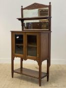 An Edwardian walnut side cabinet, the sectional bevel glazed mirror back with open shelf above two
