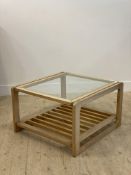 A vintage varnished pale teak coffee table, the top inset with glass above a slatted under tier,