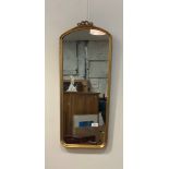 A 20th century gilt composition framed wall mirror in the classical taste with bowed ribbon surmount