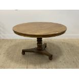 A late Regency walnut breakfast or centre table, the circular tilt top (lacking pins) raised on a