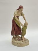 A Royal Dux Bohemia porcelain figure of a woman in traditional costume with child holding each
