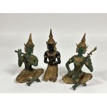 A group of three Thai cast bronze figures comprising two musicians and a praying dancer figure,