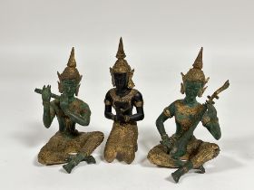 A group of three Thai cast bronze figures comprising two musicians and a praying dancer figure,