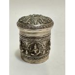 A Eastern white metal chased cylindrical container with domed top depicting various images of