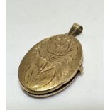 A 14ct gold oval engraved locket with twin glazed internal panels, (L x 3cm x W x 2cm) 6.25g