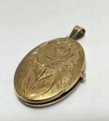 A 14ct gold oval engraved locket with twin glazed internal panels, (L x 3cm x W x 2cm) 6.25g
