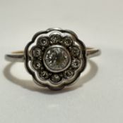 A Edwardian 18ct gold and platinum diamond cluster ring, the central old cut stone mounted in rub