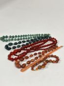 A group of six necklaces including two graduated green stone bead necklaces, (L x 22cm) a red