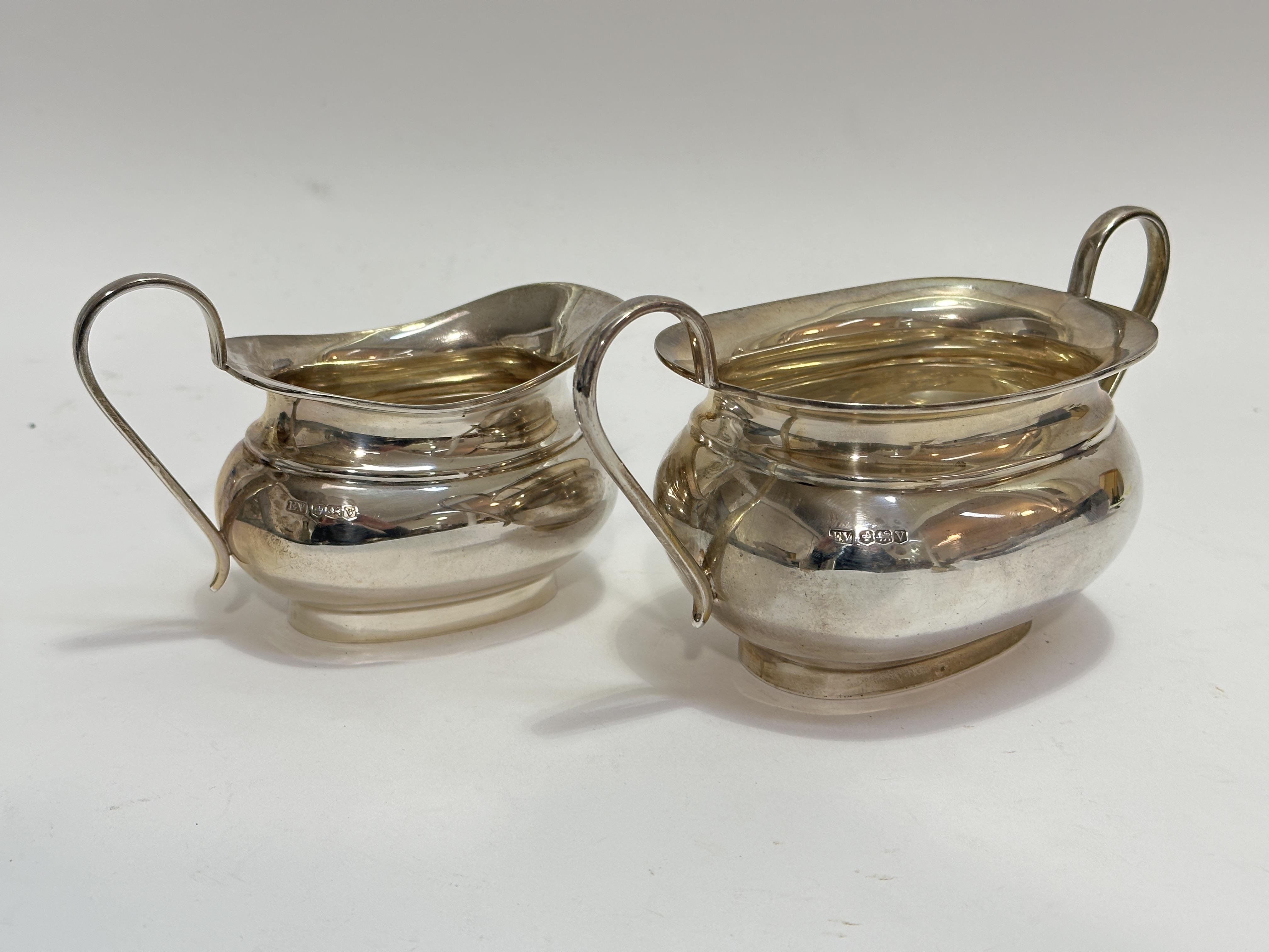 A Sheffield silver milk jug and matching twin handled sugar bowl of oval baluster form, show no