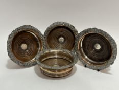 A set of four late 19thc Sheffield plated wine slides with scalloped scrolling acanthus leaf