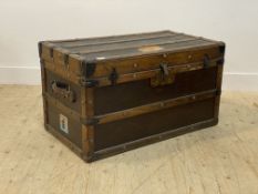 An early 20th century oak bound steamer trunk, the hinged lid opening to a paper lined interior with