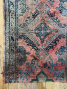 An old hand knotted Turkey runner rug, the red ground with stylised floral motifs and bordered (
