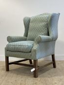 A quality Georgian style wingback chair, upholstered in pale blue floral patterned fabric, with