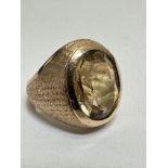 A Gold 70's style bombe dress ring set oval faceted Citrine in rub over mount with textured shank. (