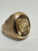 A Gold 70's style bombe dress ring set oval faceted Citrine in rub over mount with textured shank. (