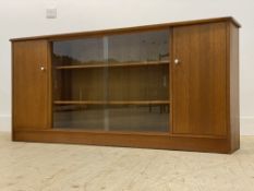 A mid century teak bookcase, with twin glazed sliding doors enclosing two adjustable shelves,