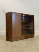 A mid century teak bookcase, with two sliding glass doors enclosing two adjustable shelves,