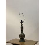 A cast brass table lamp base of faceted baluster form, in the Oriental style, with faux verdigris