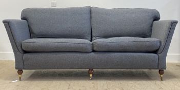 A large contemporary sofa, the upholstered frame and squab cushions covered in grey wool, raised