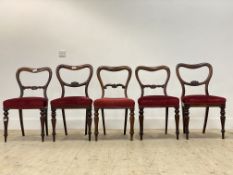 A set of five Victorian rosewood and mahogany balloon back dining chairs, with red velvet