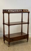 A Victorian mahogany what not, the floral pierce carved gallereid top over two under tiers on ring