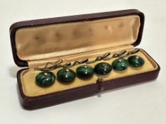 A case containing a set of six green glass dress studs complete with metal fastenings, (D x 1cm)